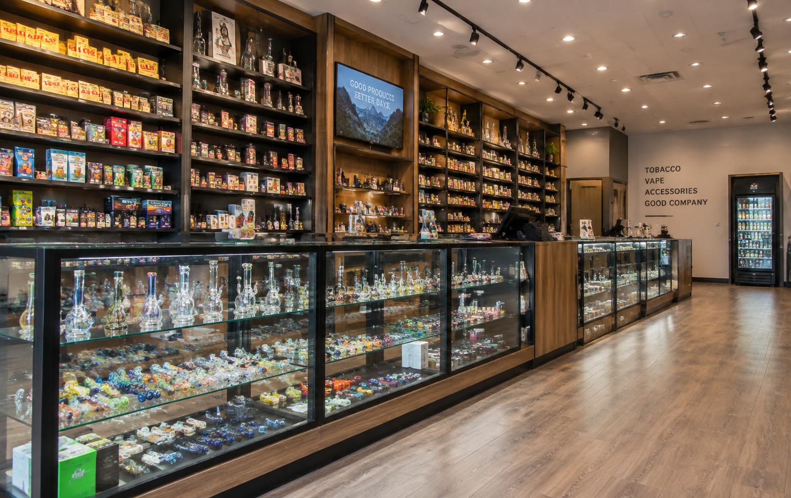 Inside Smokers Dream 2: long glass cases and stocked wall shelving